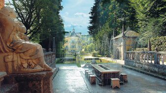 Steintisch mit Wasserfontänen, im Hintergrund Schloss Hellbrunn | © Tourismus Salzburg/Sulzer