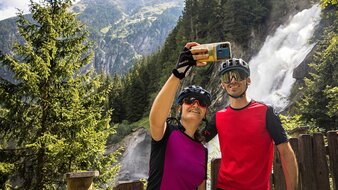 Radfahrerpärchen machen ein Selfie mit einem Wasserfall im Hintergrund | © SalzburgerLand Tourismus/Andreas Meyer