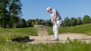 Golfspieler schlägt Ball aus Sandbunker | © SalzburgerLand Tourismus/Hansi Heckmair