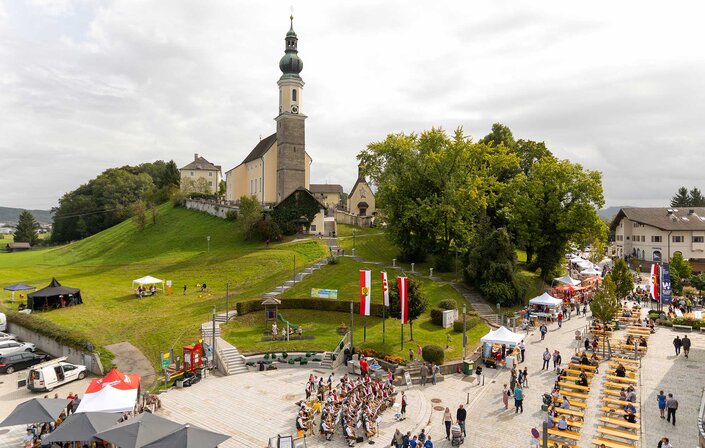 Blick von oben auf Dorfplatz mit Musikkapelle und Kirche | © Tourismusverband Bergheim