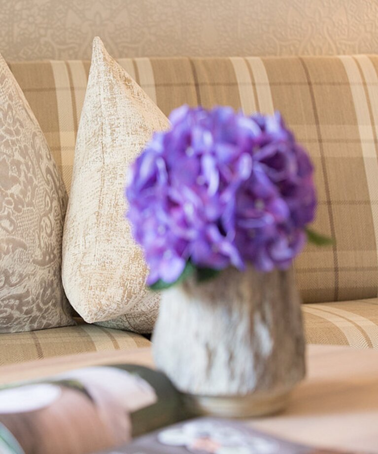 Couch mit Polter und Tisch mit Blumen | © Genussdorf Gmachl