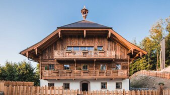 Frisch renoviertes Bauernhaus mit Holzbalkon und Holzzaun | © J. Moßhammer
