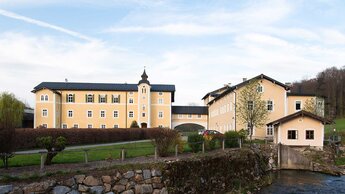 großes gelbes Gebäude mit Turm und Bach | © Tourismusverband Bergheim/Herbert Podlipnik