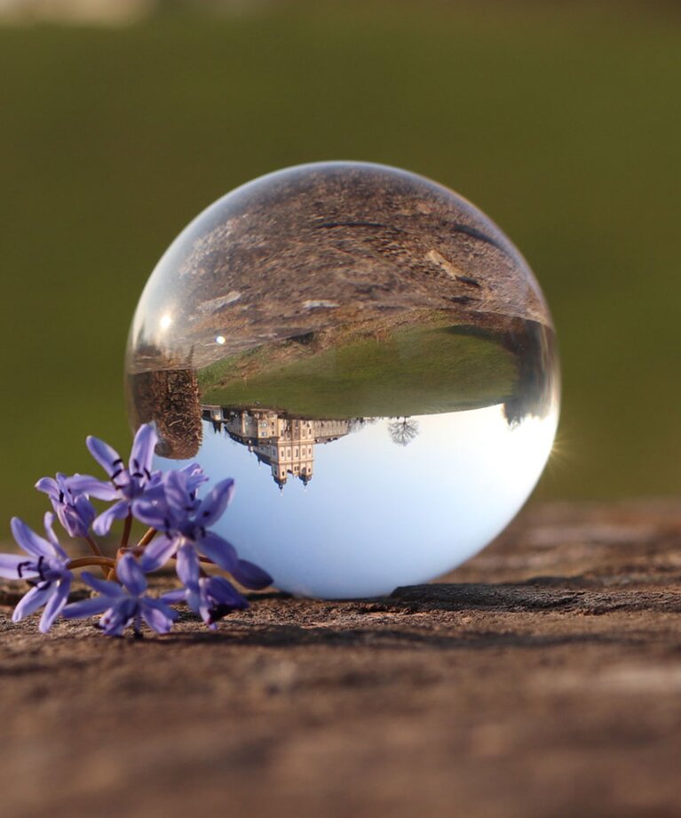 Spiegelung der Wallfahrtskirche Maria Plain in einer Glaskugel, am Kopf stehend | © Tourismusverband Bergheim/Martina Stemeseder
