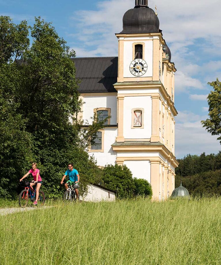 Radfahrerpärchen fährt von der Wallfahrskirche Maria Plain weg | © Tourismusverband Bergheim/Bryan Reinhart
