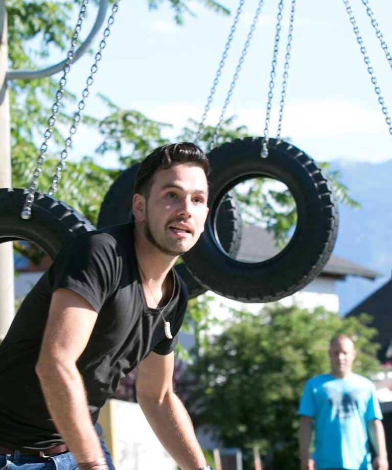 Mann läuft durch schaukelnde Reifen  | © wildbild