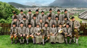 Männer und Frauen mit Blasinstrumenten, im Hintergrund Stadt Salzburg | © 1. Salzburger Jägerchor & Jagdhornbläser